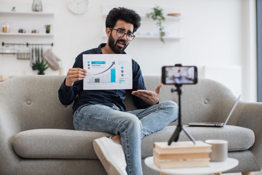Man teaching financial literacy via video on smartphone